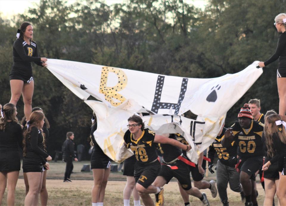 Bellevue senior Steven Meyers (78) leads the Tigers through the cheer banner that said "BHS: Simply the Best" Oct. 21, 2022 as the Tigers played a flag football game against the Bellevue police department and other adult members of the community.