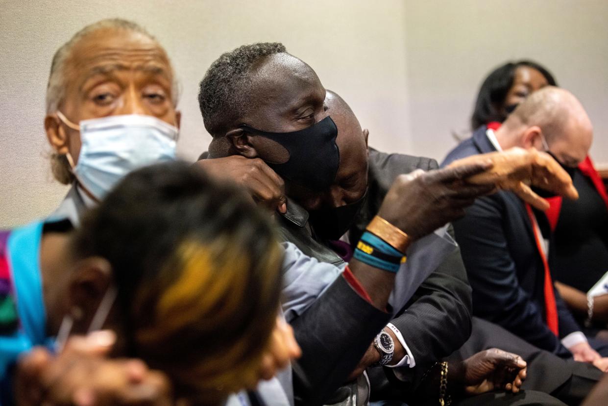 Ahmaud Arbery's father Marcus Arbery, center, his hugged by his attorney in the Glynn County Courthouse in Brunswick, Ga., on Nov. 24 after a jury convicted Travis McMichael of Arbery's murder.