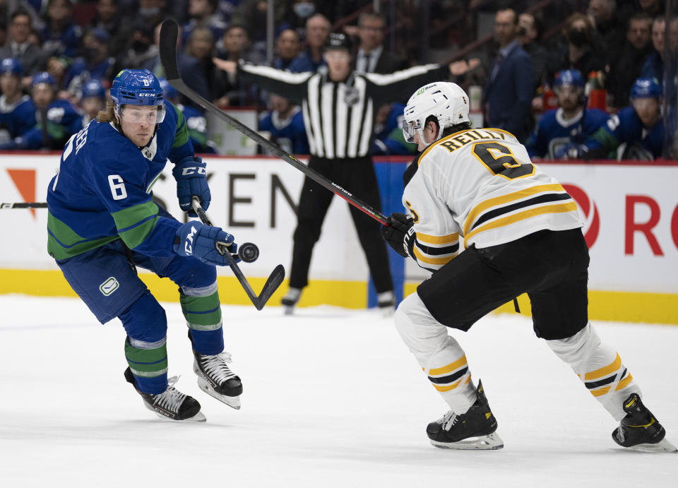 Vancouver Canucks right wing Brock Boeser (6) tries to get past Boston Bruins defenseman Mike Reilly (6) during the second period of an NHL hockey game Wednesday, Dec. 8, 2021 in Vancouver, British, Columbia. (Jonathan Hayward/The Canadian Press via AP)