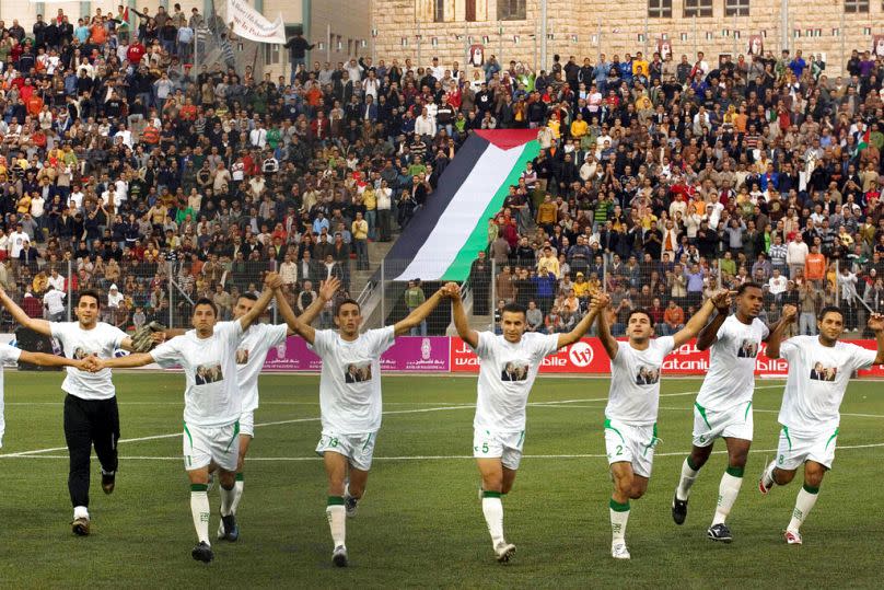 FILE - In this Oct. 26, 2008, file photo, players of the Palestinian soccer team are seen on the field prior a match with Jordan at a stadium in the West Bank town of Aram.