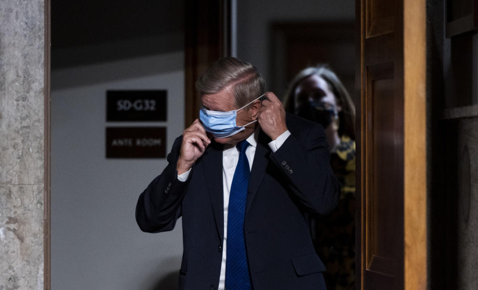 WASHINGTON, DC - NOVEMBER 17: Chairman Sen. Lindsey Graham, (R-SC), puts on his face mask as he arrives for the Senate Judiciary Committee hearing on "Breaking the News: Censorship, Suppression, and the 2020 Election" on November 17, 2020 in Washington, DC. Facebook CEO Mark Zuckerberg and Twitter CEO Jack Dorsey are scheduled to testify remotely.(Photo By Bill Clark-Pool/Getty Images)