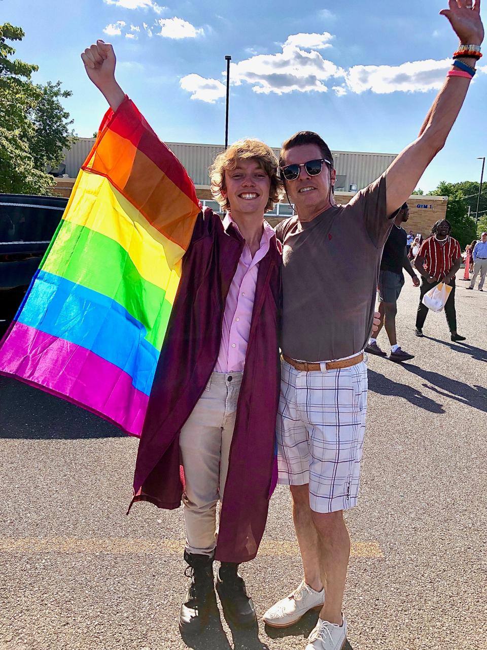Bryce Dershem and his father proudly sport his Pride flag after the graduation. During the ceremony, Dershem was asked to take off his flag.