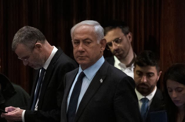 Israeli Prime Minister Benjamin Netanyahu, center, stands on the floor of the Knesset, the country's Parliament, during a vote as people mass outside to protest his government's plan to overhaul the judicial system, in Jerusalem on March 27.