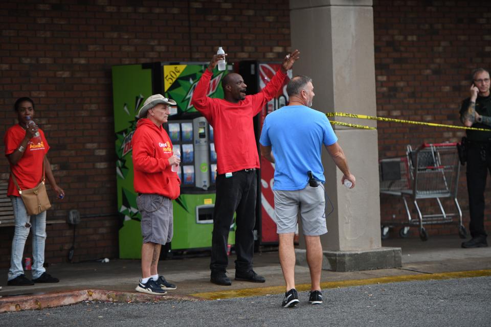 A Grocery Advantage employee talks to the store's owner Thursday, Aug. 15, 2019, about an active shooter who fired inside the store before being shot by an Escambia County Sheriff's Office deputy.