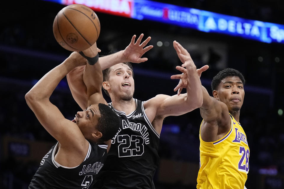 San Antonio Spurs forward Keldon Johnson, left, forward Zach Collins, center, and Los Angeles Lakers forward Rui Hachimura go after a rebound during the first half of an NBA basketball game Wednesday, Jan. 25, 2023, in Los Angeles. (AP Photo/Mark J. Terrill)