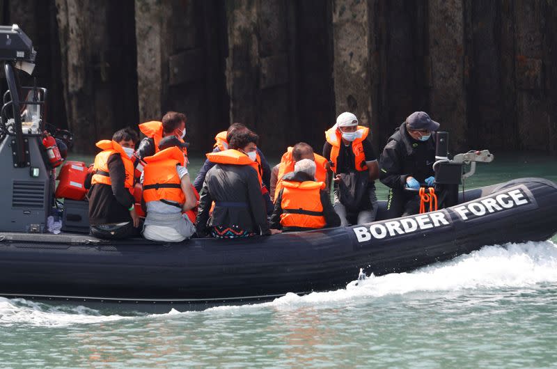 Migrants react as they are brought to Dover harbour by Border Force, in Dover