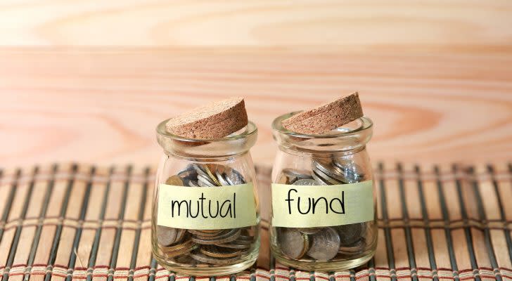 mutual funds to buy: Coins in jar. Writing Mutual Fund on two jar with wooden pallet background.