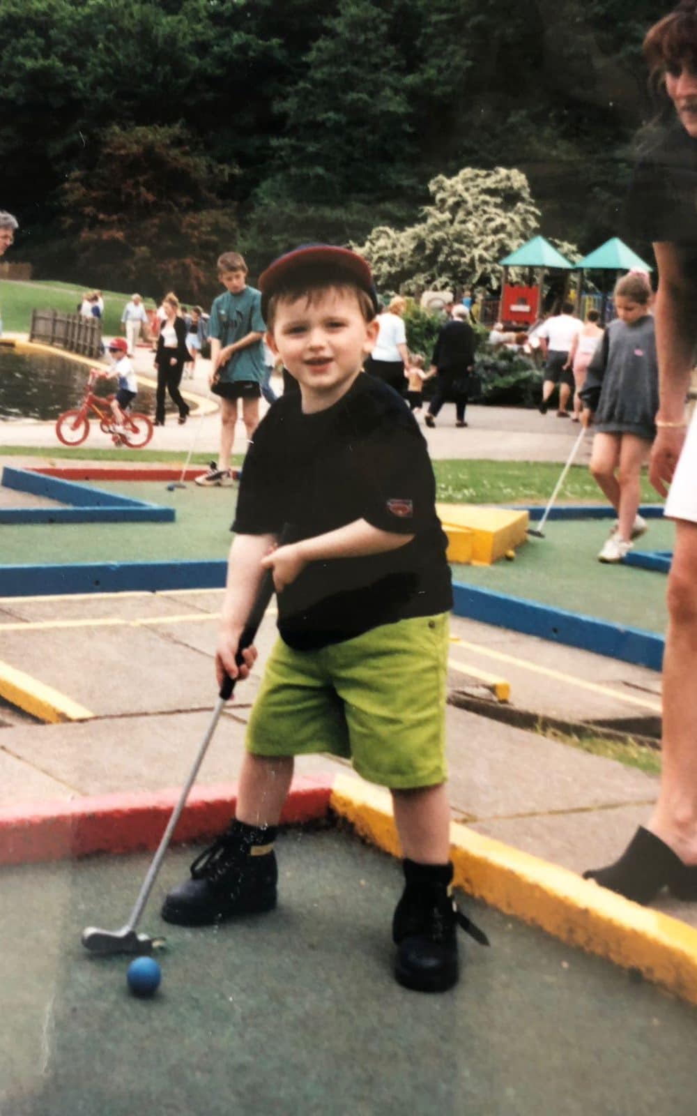 Ash Turner playing crazy golf as a youngster, watched over by his mother Angela (right) - Family photograph