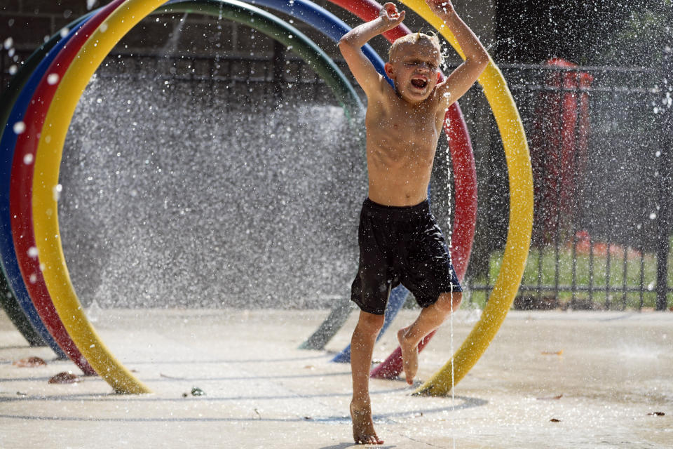 Ryanland Brown, 7, runs through a splash pad at a park Friday, June 30, 2023 in Nashville, Tenn. Weather forecasts call for heat indexes to reach over 105 degrees Fahrenheit for the Middle Tennessee area through the weekend. (AP Photo/George Walker IV)