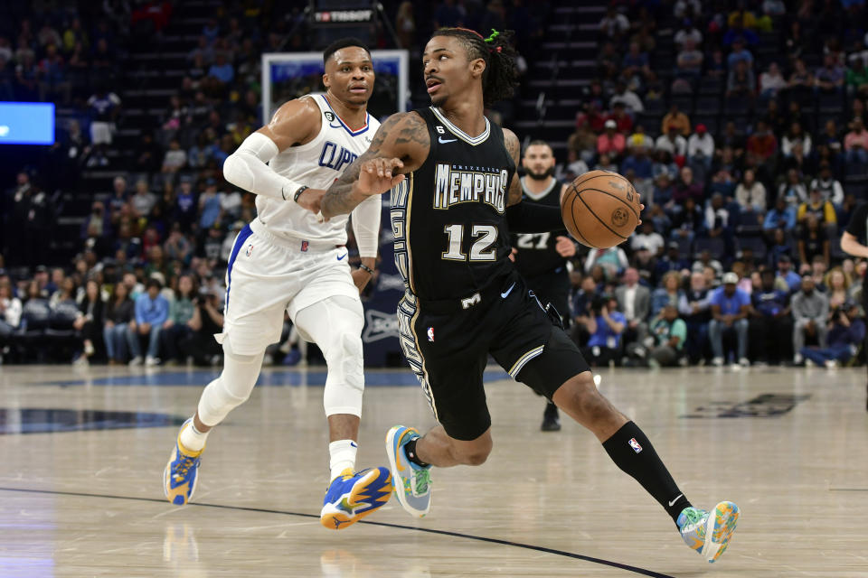 Memphis Grizzlies guard Ja Morant (12) handles the ball ahead of Los Angeles Clippers guard Russell Westbrook, left, in the first half of an NBA basketball game Friday, March 31, 2023, in Memphis, Tenn. (AP Photo/Brandon Dill)