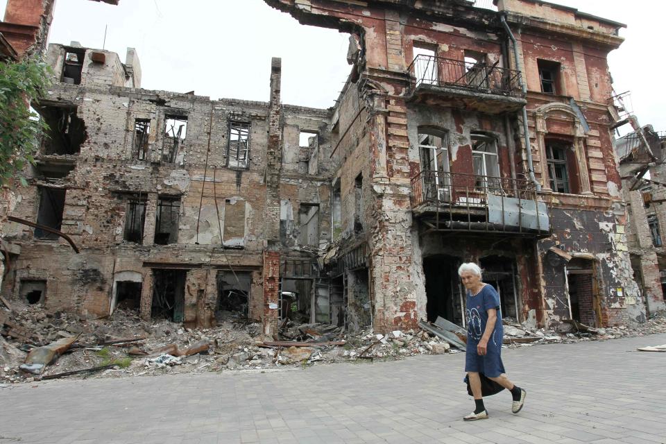 A woman walks past a destroyed building in the Russian-controlled Azov Sea port city of Mariupol (AFP via Getty Images)