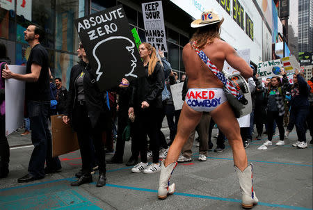 Protesters walk through Times Square during the Earth Day 'March For Science NYC' demonstration to coincide with similar marches globally in Manhattan, New York, U.S., April 22, 2017. REUTERS/Andrew Kelly