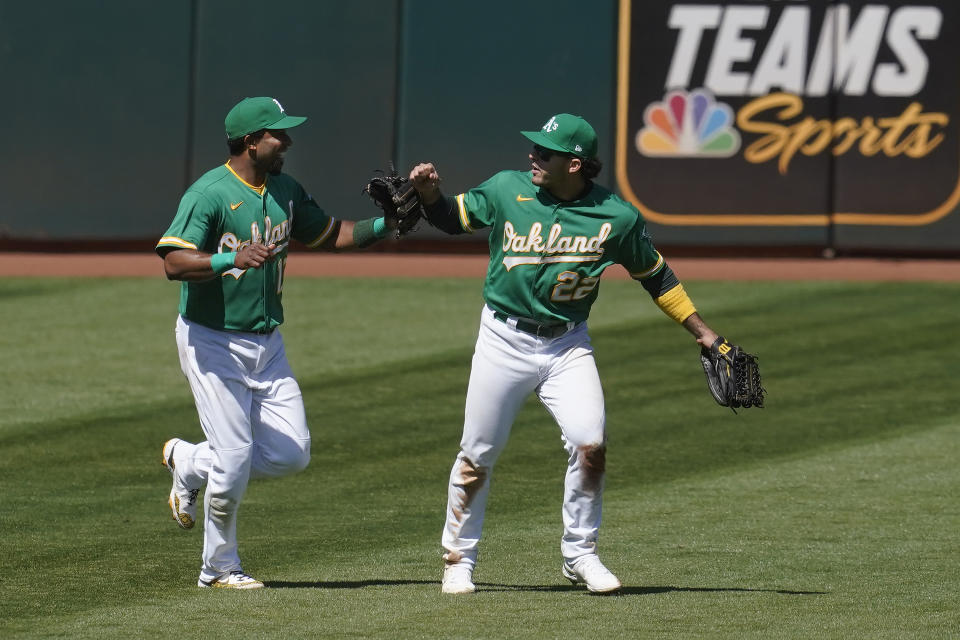 Oakland Athletics shortstop Elvis Andrus, left, celebrates with center fielder Ramon Laureano after the Athletics defeated the Seattle Mariners in a baseball game in Oakland, Calif., Wednesday, May 26, 2021. (AP Photo/Jeff Chiu)