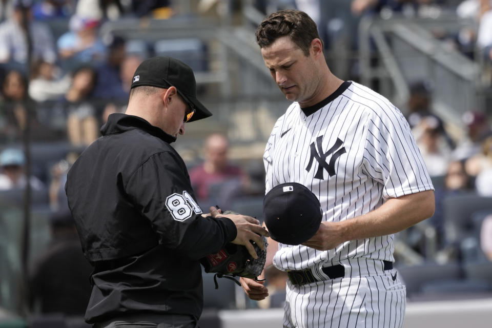 Umpire Quinn Wolcott (81) check New York Yankees pitcher Gerrit Cole's glove in the fourth inning of a baseball game against the Toronto Blue Jays, Saturday, April 22, 2023, in New York. (AP Photo/Mary Altaffer)