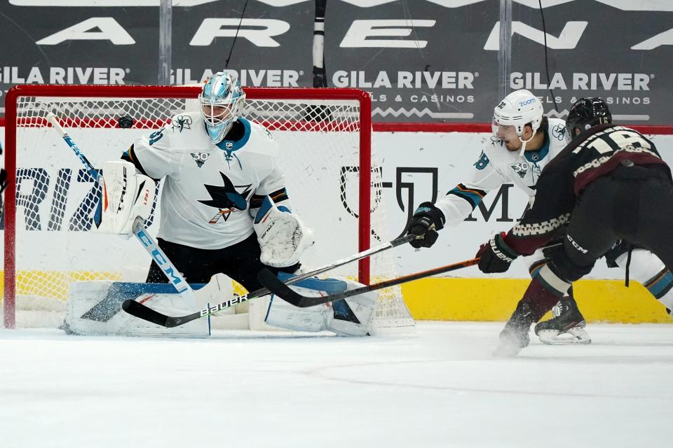 San Jose Sharks goaltender Martin Jones (31) makes a save on a shot from Arizona Coyotes center Derick Brassard (16) as Sharks defenseman Mario Ferraro (38) pressures Brassard during the second period of an NHL hockey game Saturday, Jan. 16, 2021, in Glendale, Ariz. (AP Photo/Ross D. Franklin)