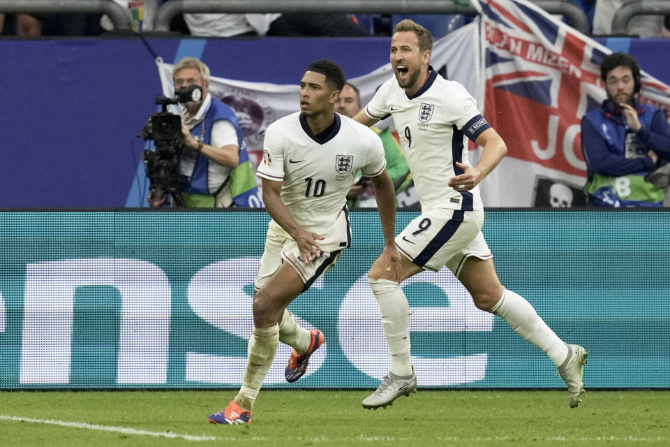 England's Jude Bellingham celebrates with Harry Kane, right, after scoring his side's first goal during a round of sixteen match between England and Slovakia at the Euro 2024 soccer tournament in Gelsenkirchen, Germany, Sunday, June 30, 2024. (AP Photo/Thanassis Stavrakis)