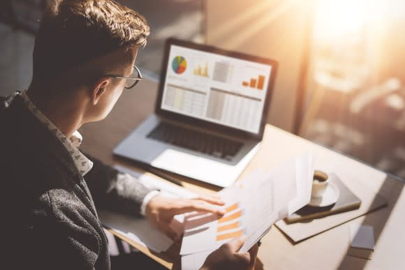 An investor researches an investment on a laptop.