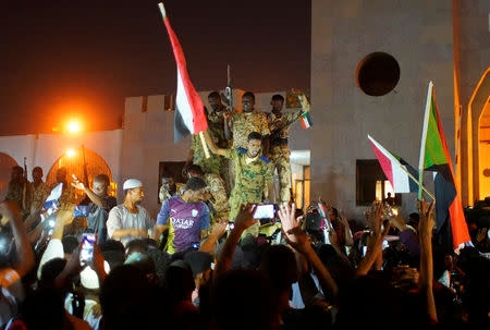 Sudanese military join demonstrators to celebrate after the Defence Minister Awad Ibn Auf stepped down as head of the country's transitional ruling military council, as protesters demanded quicker political change, outside the Defence Ministry in Khartoum, Sudan April 13, 2019. REUTERS/Stringer