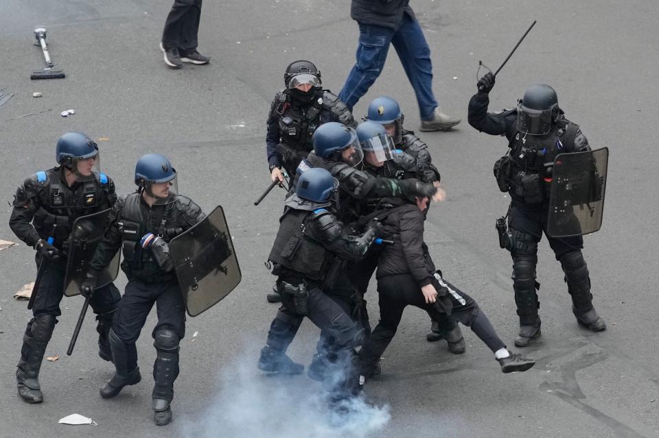 Riot police scuffle with a protester during a rally in Paris (AP)