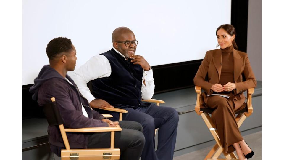 David Oyelowo, Misan Harriman and Meghan Markle in a brown suit all sat on chairs