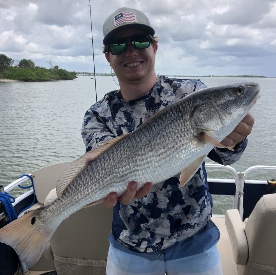 Jacob Sanford shows off a 26-inch redfish he caught while fishing in Oak Hill with Art Mowery.
