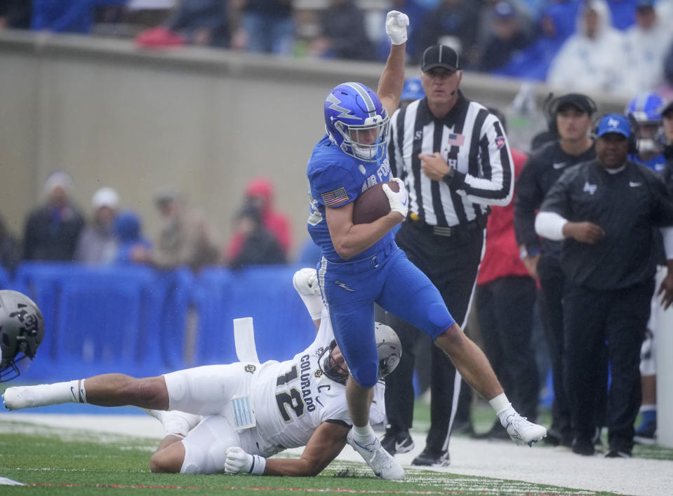 Air Force wide receiver Dane Kinamon, front, is knocked out of bounds by Colorado linebacker Quinn Perry in the first half of an NCAA college football game Saturday, Sept. 10, 2022, at Air Force Academy, Colo. (AP Photo/David Zalubowski)