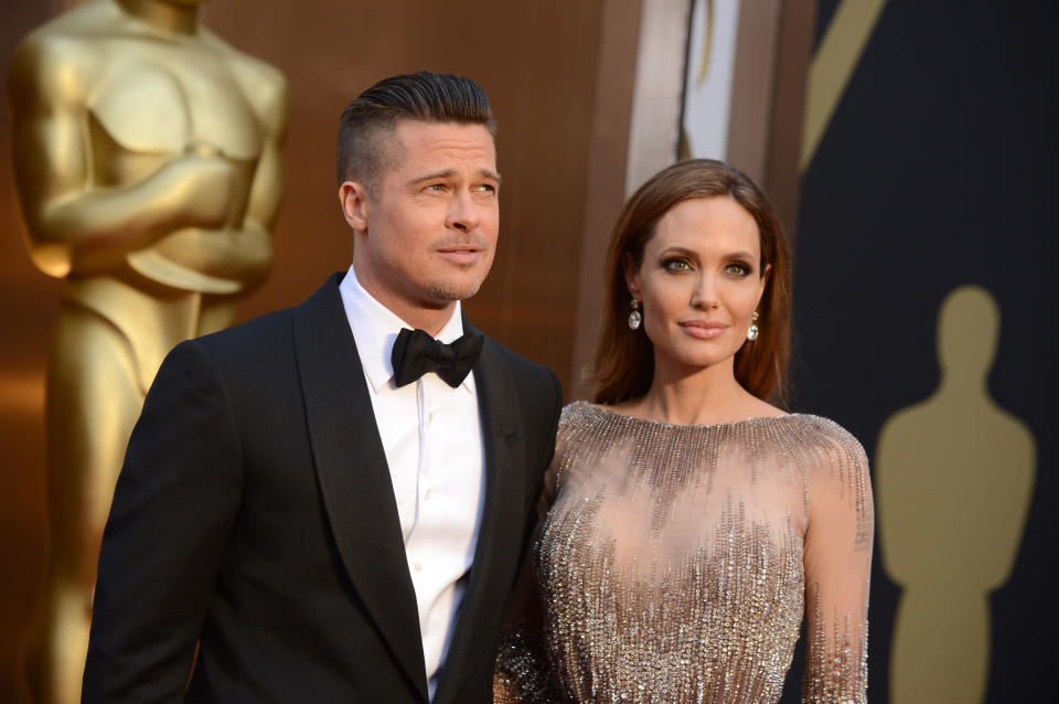 Brad Pitt, left, and Angelina Jolie arrive at the Oscars on Sunday, March 2, 2014, at the Dolby Theatre in Los Angeles.  (Photo by Jordan Strauss/Invision/AP)