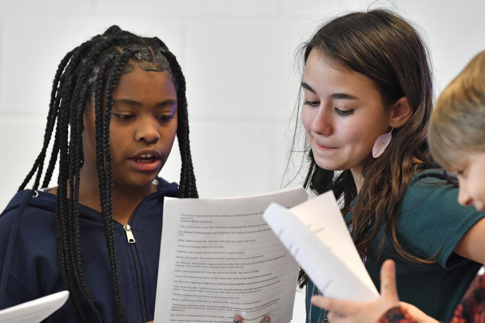 Kimaya Johnson, left, and Bella Whitice go over their lines of a play written by ChatGPT in Donnie Piercey's class at Stonewall Elementary in Lexington, Ky., Monday, Feb. 6, 2023. Parameters of the play were entered into the ChatGPT site, along with instructions to set the scenes inside of a fifth-grade classroom. Line-by-line, it generated fully-formed scripts, which the students edited, briefly rehearsed and then performed. (AP Photo/Timothy D. Easley)