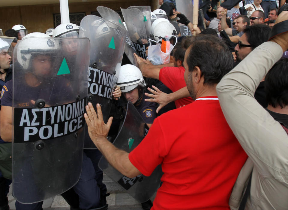 Riot police clash with protesters inside Greece's Defense Ministry in Athens, Thursday, Oct. 4, 2012. Police clashed with scores of protesting shipyard workers after they forced their way into the grounds of Greece's Defense Ministry. The workers say they have not been paid in months. (AP Photo/Thanassis Stavrakis)
