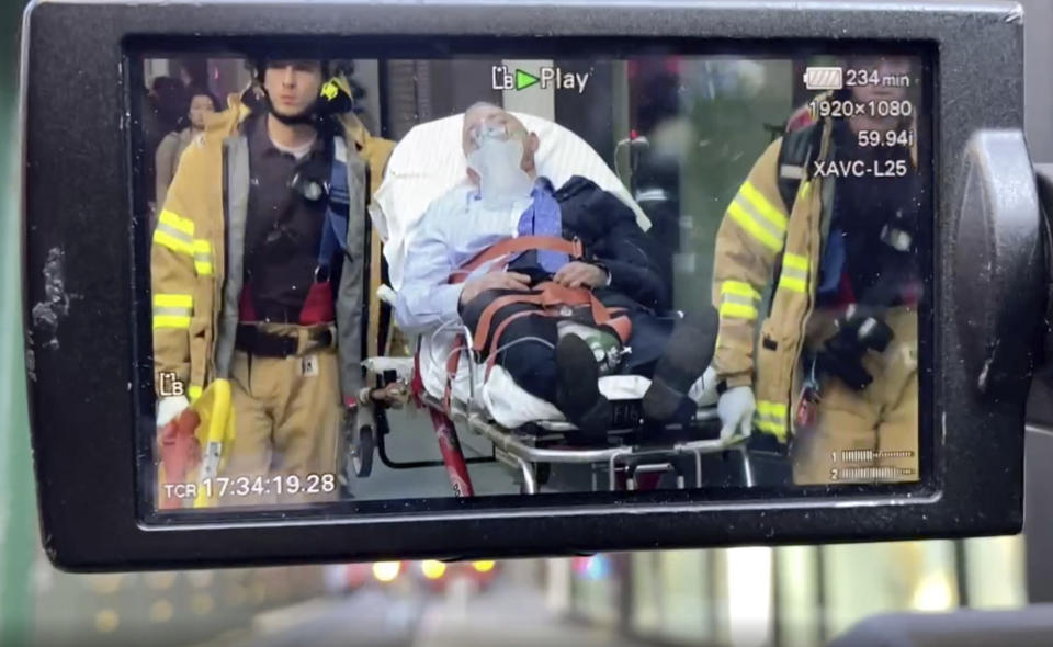 In this image taken from video of video being recorded at the scene, New York City Fire Department personnel carry a person on a stretcher away from an area in New York's Financial District, Tuesday, April 18, 2023, following the partially collapsed of a parking garage. (AP Photo/Ted Shaffrey)