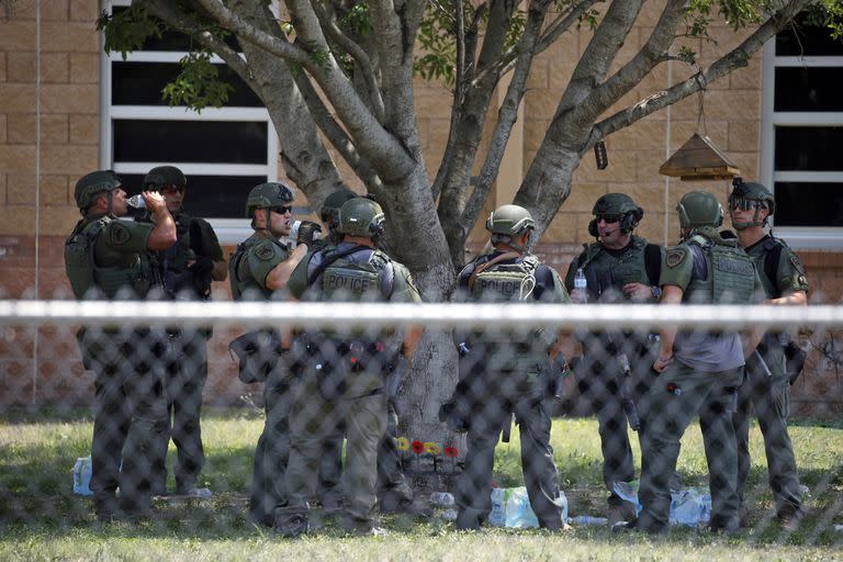 Agentes del orden parados afuera de la Escuela Primaria Robb tras el tiroteo fatal el 24 de mayo 