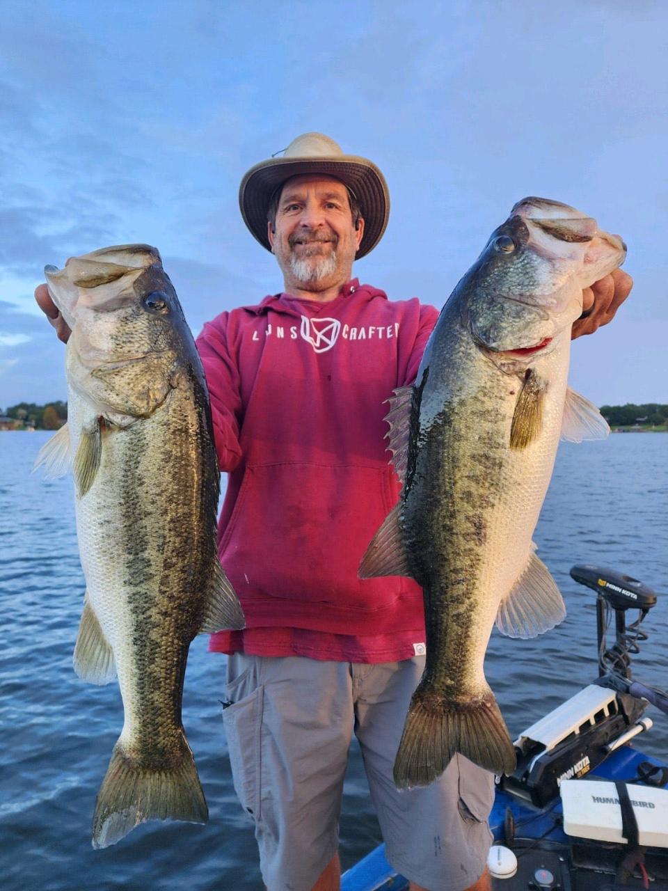 Alan Lyons, of Ventura, California, shows off a couple of 6-pound bass he caught while on a guided fishing tour with Capt. Bill Goudy.