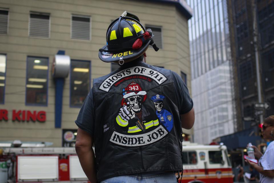 A man stands before a moment of silence honoring the victims of the 9/11 attacks, outside the World Trade Center site in New York September 11, 2013. Bagpipes, bells and a reading of the names of the nearly 3,000 people killed when hijacked jetliners crashed into the World Trade Center, the Pentagon and a Pennsylvania field marked the 12th anniversary of the September 11 attacks in 2001. (REUTERS/Shannon Stapleton)