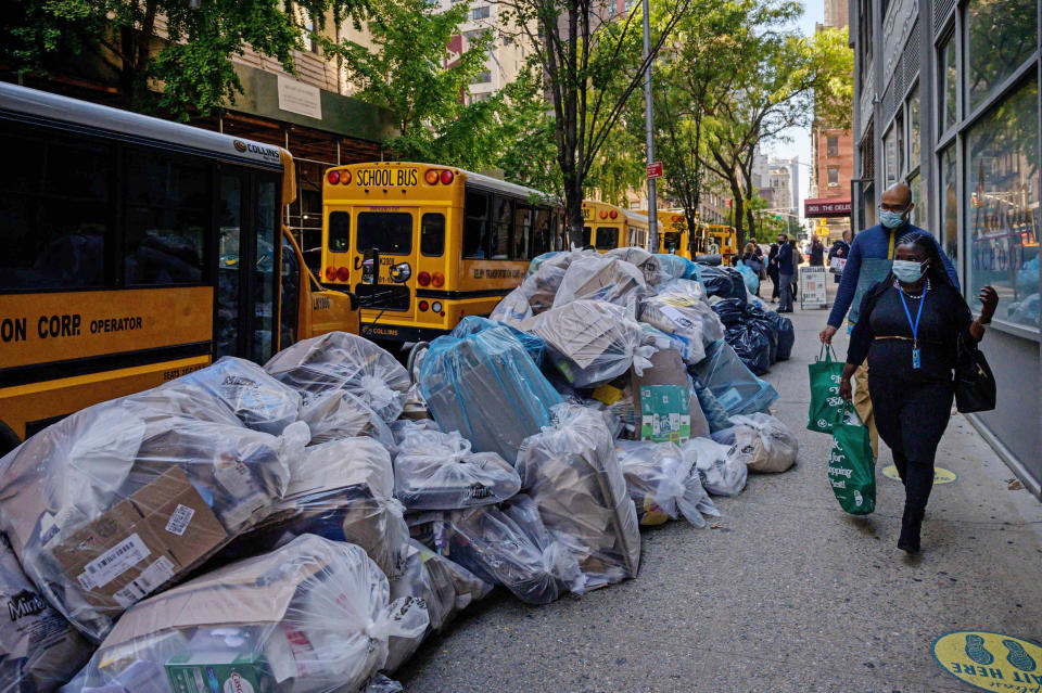 Pedestrians pass by trash bags piled on a street in New York on Oct. 28, 2021. (Ed Jones / AFP - Getty Images)