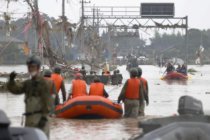 Local residents are rescued by Japanese Self-Defence Force soldiers using a boat at a flooding area caused by a heavy rain in Kuma village