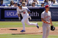 Los Angeles Dodgers' Will Smith, left, runs to first after hitting a two RBI double as Cincinnati Reds starting pitcher Tyler Mahle watches during the fourth inning of a baseball game Sunday, April 17, 2022, in Los Angeles. (AP Photo/Mark J. Terrill)