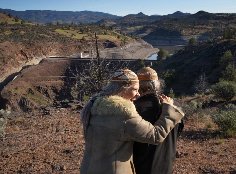 Karuk Tribal member Lisa Hillman, left, gives her husband Leaf Hillman a hug on an overlook above Iron Gate Dam as crews begin the removal of the top layer of the earthen dam that blocks the Klamath River east of Yreka, Calif., on May 1, 2024.
