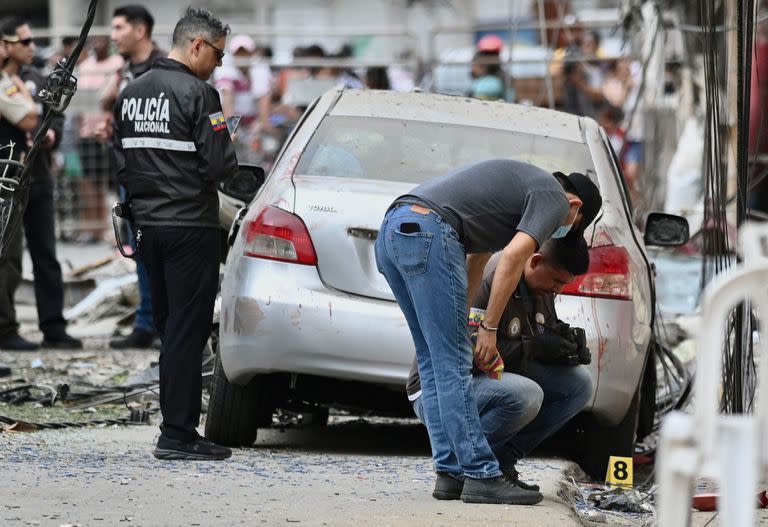 Miembros de la Policía Nacional inspeccionan el lugar de una explosión, que el gobierno ecuatoriano atribuye al crimen organizado, en el sur de Guayaquil, Ecuador, el 14 de agosto de 2022.