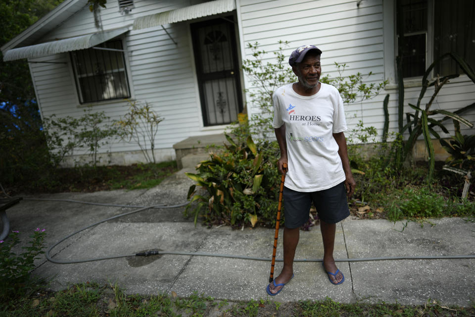 Anthony Dinkins, a third-generation town resident, stands in front of his family's lakeside home in the historically Black town of Eatonville, Fla., Wednesday, Aug. 23, 2023. Dinkins said the family lost two thirds of their property when Interstate 4 was built through the heart of town in the late 1950s, and his grandmother's house had to be relocated nearby. (AP Photo/Rebecca Blackwell)