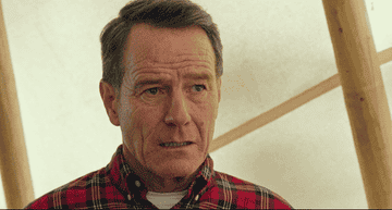 Bryan Cranston wearing a plaid shirt, laughing