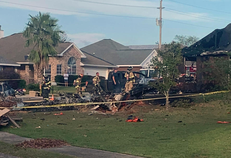 Firefighters pictured around a crater on a front lawn.