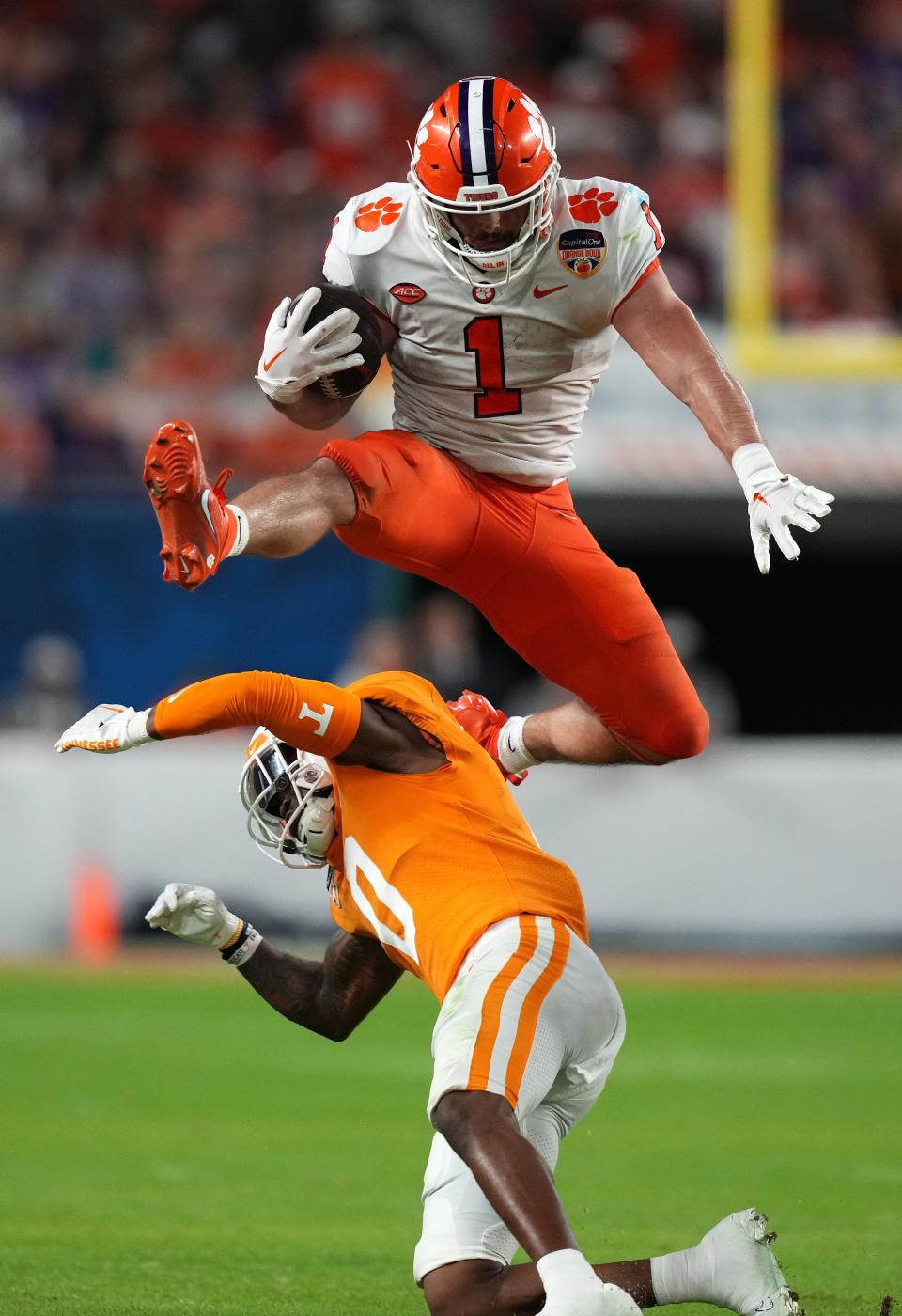 Dec 30, 2022; Miami Gardens, FL, USA; Clemson Tigers running back Will Shipley (1) leaps over Tennessee Volunteers defensive back Doneiko Slaughter (0) during the first half of the 2022 Orange Bowl at Hard Rock Stadium. Mandatory Credit: Jasen Vinlove-USA TODAY Sports