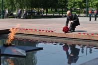 Russian President lays a bunch of flowers at the eternal flame in memory of those killed during WWII as he takes part in a wreath laying ceremony at the Tomb of Unknown Soldier in Moscow, Russia, Tuesday, June 22, 2021, marking the 80th anniversary of the Nazi invasion of the Soviet Union. (Alexei Nikolsky, Sputnik, Kremlin Pool Photo via AP)