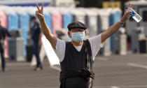 An Orange County resident cheers after getting a vaccine at the Disneyland Resort serving as a Super POD (Point of Dispensing) COVID-19 mass vaccination site Wednesday, Jan. 13, 2021, in Anaheim, Calif. California is immediately allowing residents 65 and older to get scarce coronavirus vaccines, Gov. Gavin Newsom announced Wednesday. (AP Photo/Damian Dovarganes)