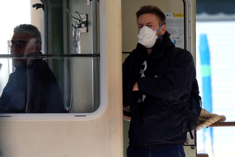 A water bus worker wearing a protective mask is seen in Venice on Sunday with an unprecedented lockdown across of all Italy imposed to slow the outbreak of coronavirus