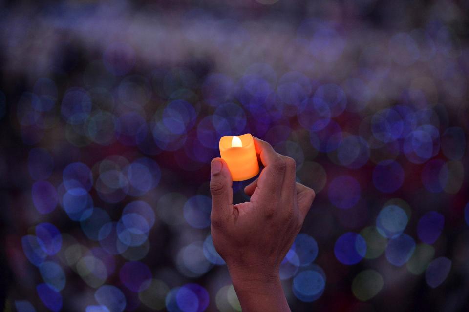 Catholic faithful hold up LED candles as Pope Francis attends a meeting with Filipino families in Manila