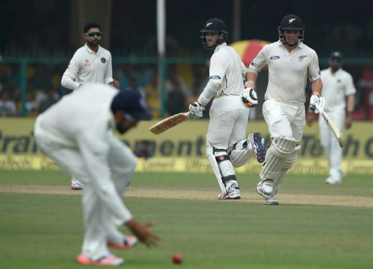 New Zealand's captain Kane Williamson (centre) and batsman Tom Latham run between wickets during the second day of their first Test match against India in Kanpur on September 23, 2016