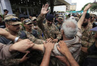 A supporter of Tahir ul-Qadri, a Sufi cleric and leader of Pakistan Awami Tehreek (PAT) party, cheers upon seeing an army commander after fellow supporters stormed the building of the state television channel PTV, during the Revolution March in Islamabad September 1, 2014. REUTERS/Faisal Mahmood