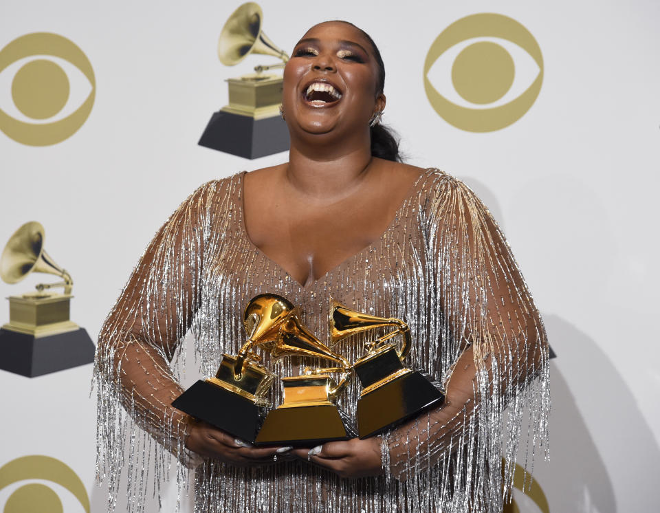 Lizzo poses in the press room with the awards for best pop solo performance for "Truth Hurts", best urban contemporary album for "Cuz I Love You" and best traditional R&B performance for "Jerome" at the 62nd annual Grammy Awards at the Staples Center on Sunday, Jan. 26, 2020, in Los Angeles. (AP Photo/Chris Pizzello)