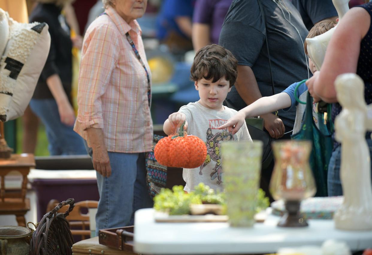 Oliver Pfeiffer, left, and his brother Jacob, right, check out a pumpkin for sale at the Moss Avenue Sale Saturday morning.